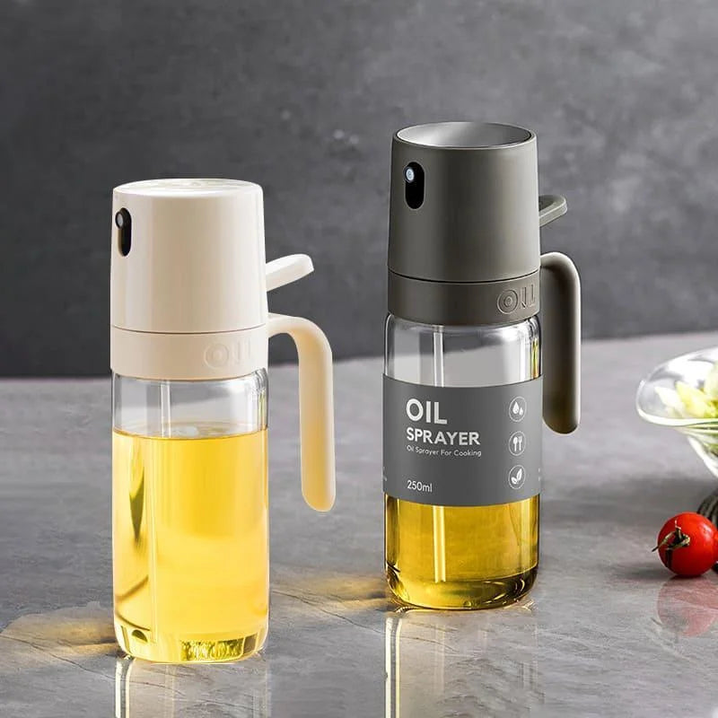 Dois borrifadores de azeite para cozinha, um bege e outro cinza, com capacidade de 250ml, sobre bancada cinza