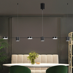 Sala de jantar com mesa branca, cadeiras verdes, banco acolchoado e luminária pendente moderna