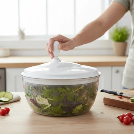 Pessoa usando centrífuga de salada transparente com tampa branca na bancada da cozinha com legumes frescos